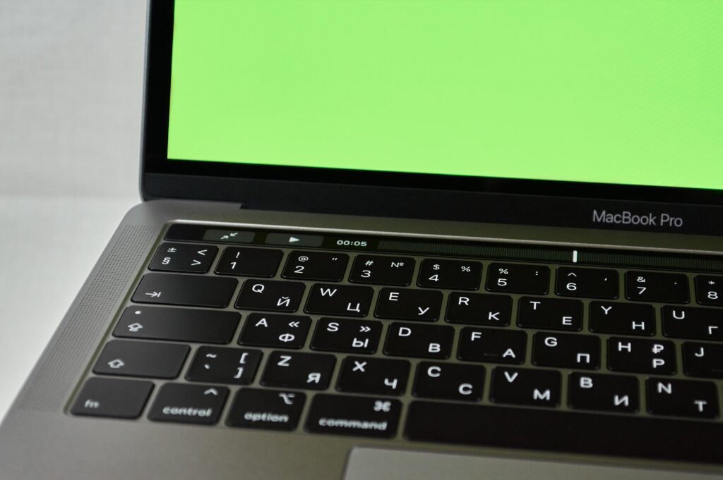 pexels photo 3822336 3822336 Russian keyboard MacBook Pro with a green screen. Modern electronic device.